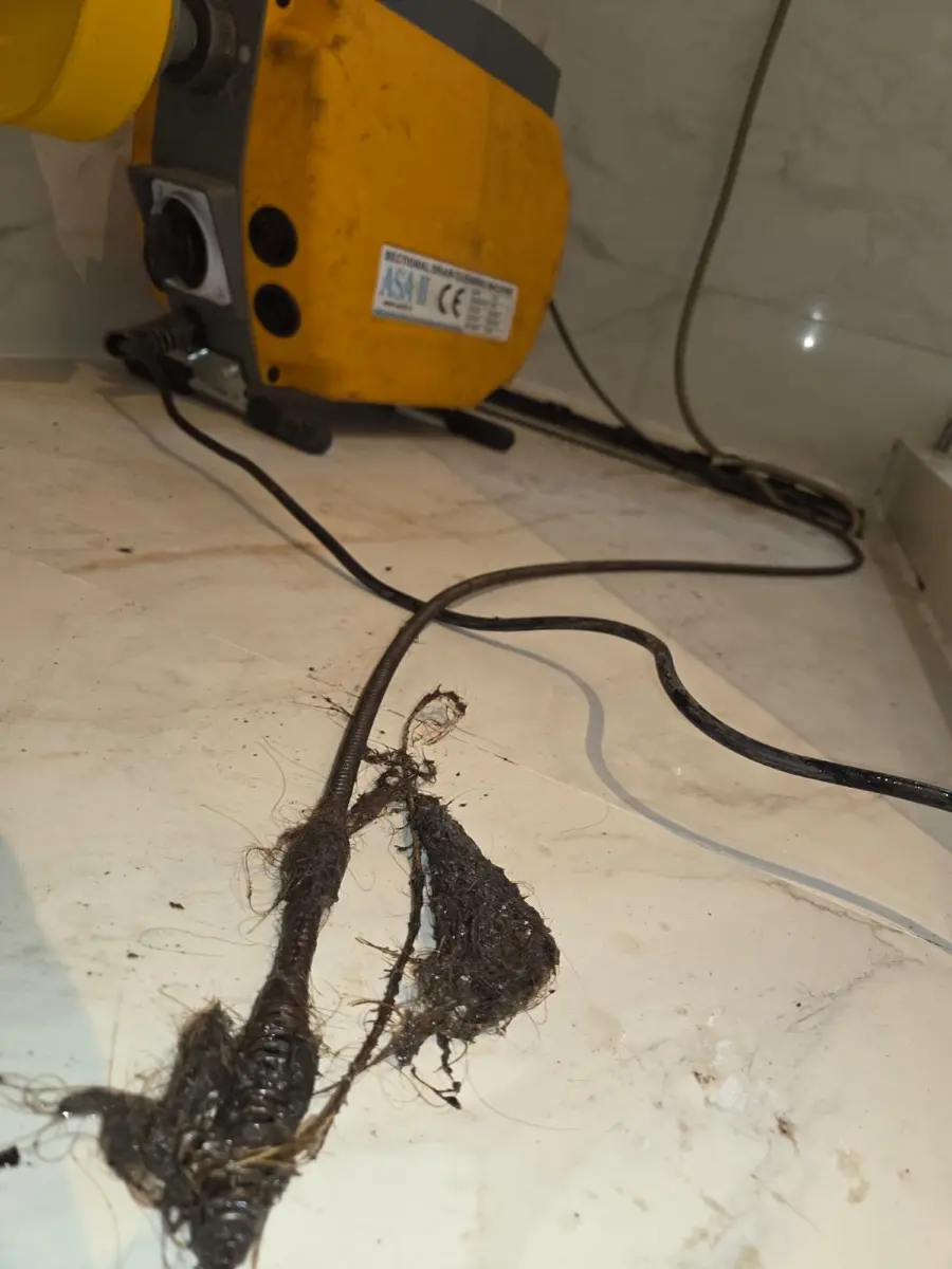 Máquina eléctrica destapando una ducha tapada con pelos — trabajo real de destapando.cl